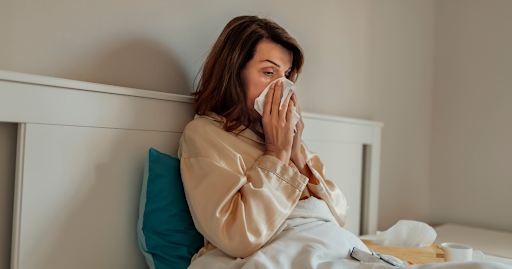 Woman resting in bed with illness symptoms representing weakened immune system and need for stem cell therapy support