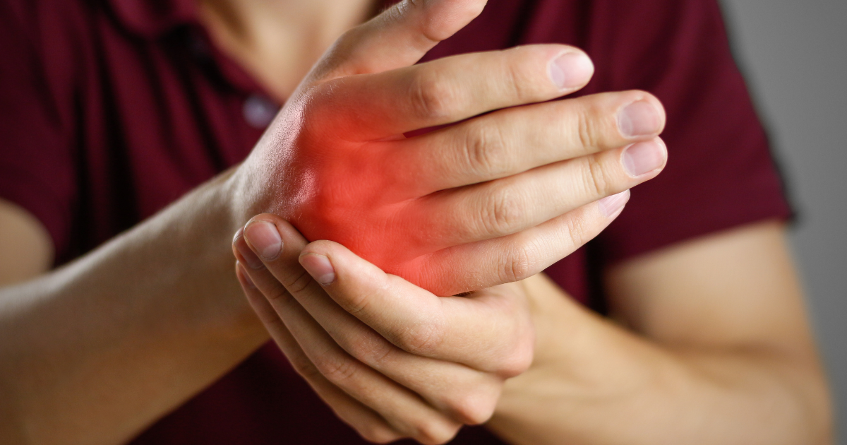 Person holding a painful inflamed hand and wrist, representing arthritis, joint pain, and non-surgical arthritis treatment options